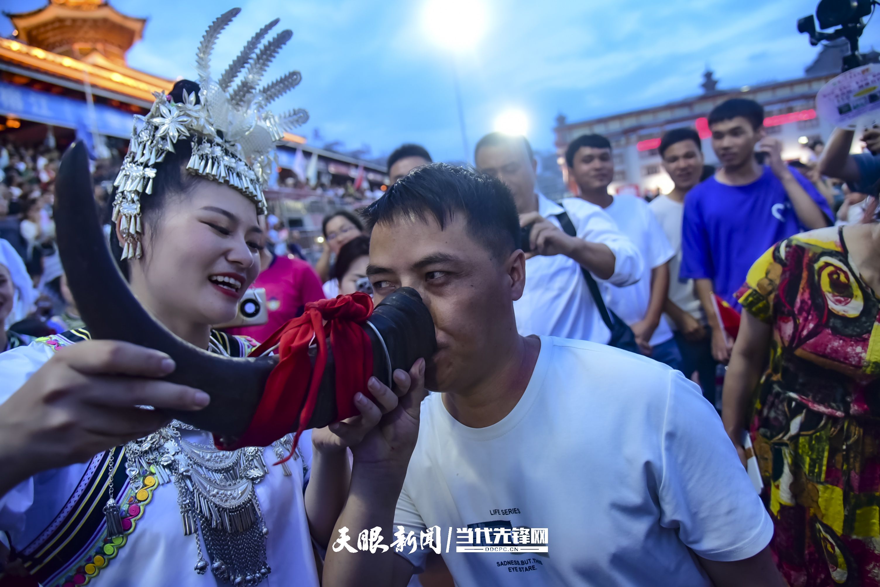 村超現(xiàn)場，當?shù)厝罕娤蜻h道而來的游客敬酒。 潘邵平 攝.jpg