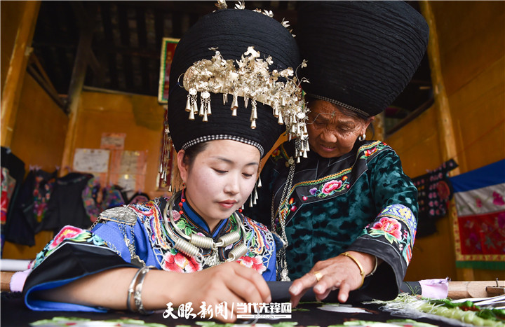 在貴州省銅仁市松桃苗族自治縣太平營(yíng)街道老寨村，一老人在指導(dǎo)繡娘繡苗繡。.jpg